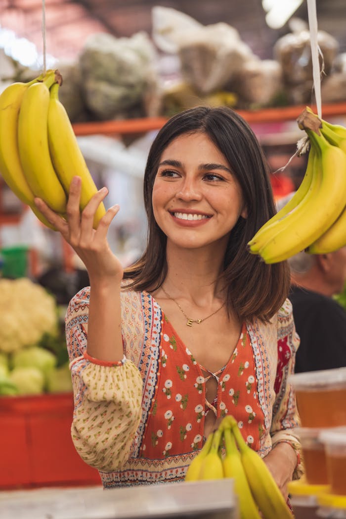 Selective Focus Photo of a Woman Touching Yellow Bananas